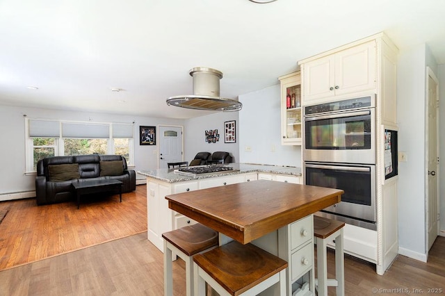 38 Black Bridge Rd, Newtown, CT 06482 - kitchen featuring appliances with stainless steel finishes, light wood-style flooring, a peninsula, open floor plan, and glass insert cabinets