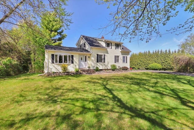 rear view of house with a chimney and a lawn