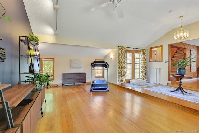 interior space featuring a ceiling fan, a wealth of natural light, light wood-style floors, and vaulted ceiling