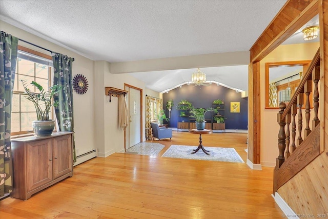 foyer featuring a notable chandelier, a baseboard radiator, baseboards, stairway, and light wood-type flooring