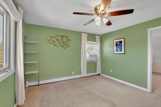 spare room with carpet flooring, baseboards, a ceiling fan, and baseboard heating