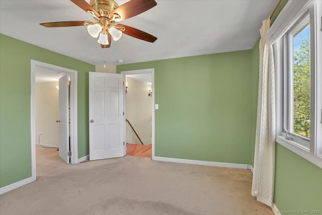 unfurnished bedroom with carpet flooring, multiple windows, and baseboards