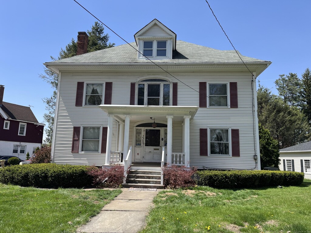 225 Vine St, New Britain, CT 06052 - view of front of home featuring covered porch, a chimney, and a front yard