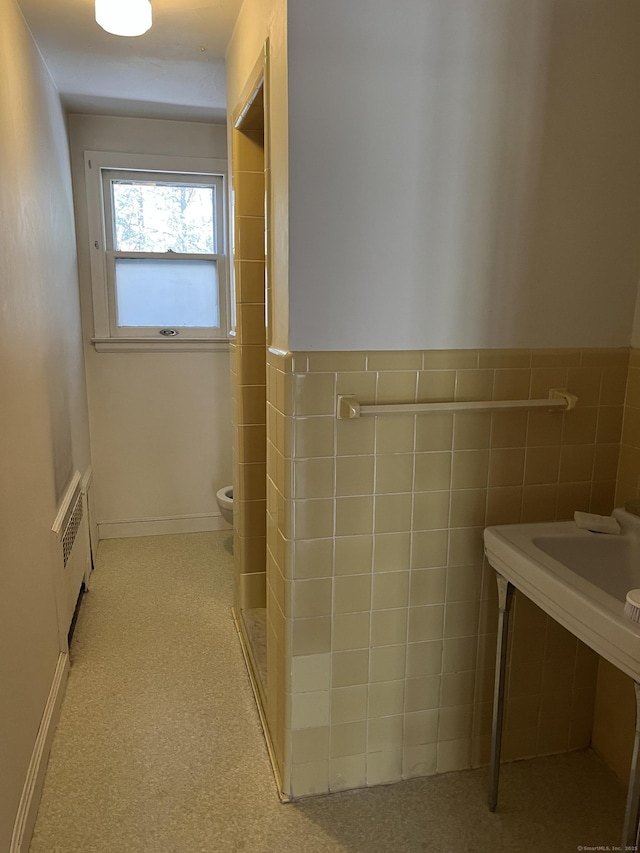 bathroom featuring toilet, walk in shower, and radiator heating unit