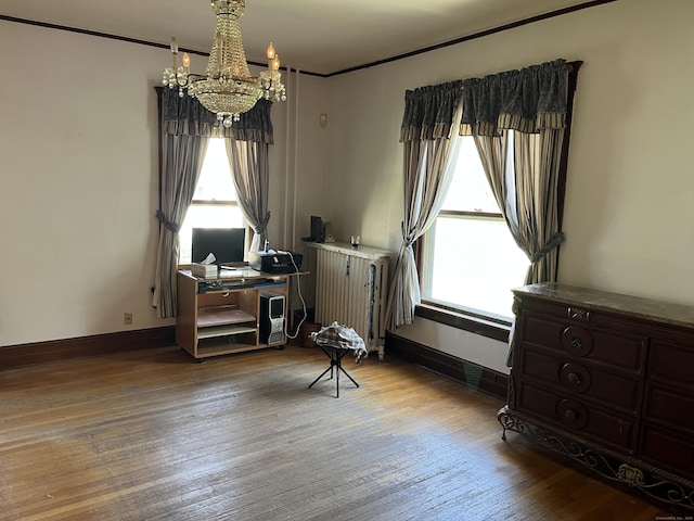 office area with an inviting chandelier, wood-type flooring, crown molding, and baseboards