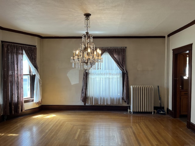 unfurnished dining area with radiator heating unit, crown molding, an inviting chandelier, and a healthy amount of sunlight