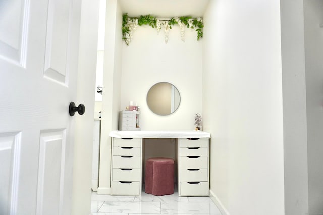 bathroom featuring marble look tile flooring and baseboards