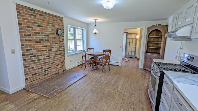 32 Great Hill Pond Rd, Portland, CT 06480 - kitchen with stainless steel range with gas stovetop, baseboards, under cabinet range hood, and light wood-type flooring
