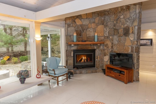 sitting room with a stone fireplace and tile patterned flooring