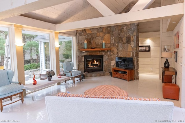 living area featuring wood ceiling, lofted ceiling with beams, tile patterned floors, and a stone fireplace