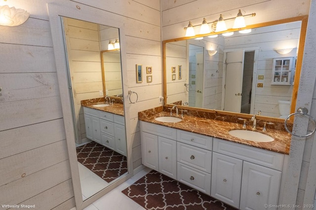 bathroom with a sink and wood walls