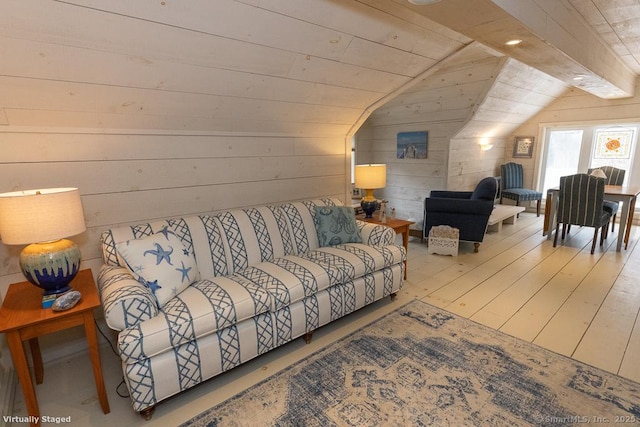 living area with wooden walls, hardwood / wood-style flooring, and lofted ceiling
