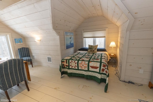 bedroom featuring visible vents, wooden walls, vaulted ceiling, and wood ceiling
