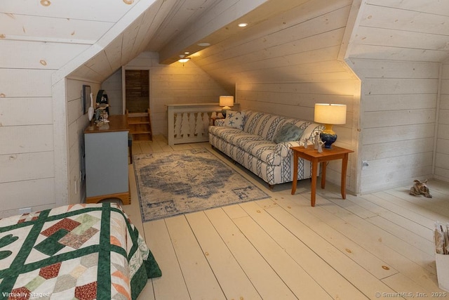bedroom with wood walls, vaulted ceiling, hardwood / wood-style flooring, and wooden ceiling
