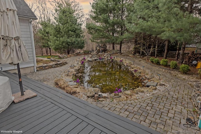 pool at dusk with a garden pond and fence