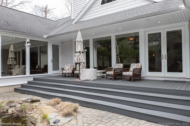 view of patio / terrace with french doors, a wooden deck, and an outdoor living space