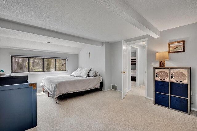 carpeted bedroom featuring baseboards, a textured ceiling, visible vents, and beam ceiling