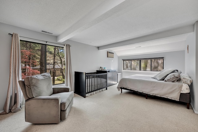 bedroom with carpet flooring, a textured ceiling, multiple windows, and beam ceiling