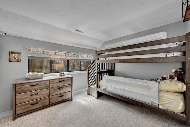 bedroom featuring visible vents, a textured ceiling, lofted ceiling, and light colored carpet