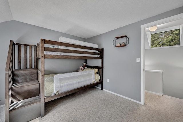 bedroom with baseboards, carpet flooring, and a textured ceiling