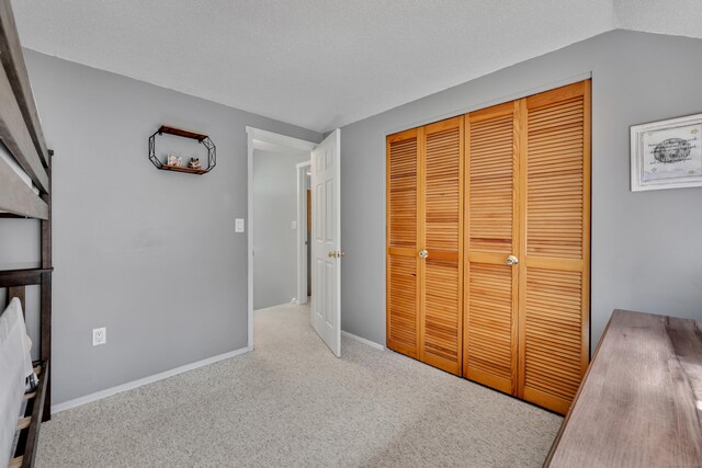 unfurnished bedroom featuring a closet, baseboards, and carpet flooring