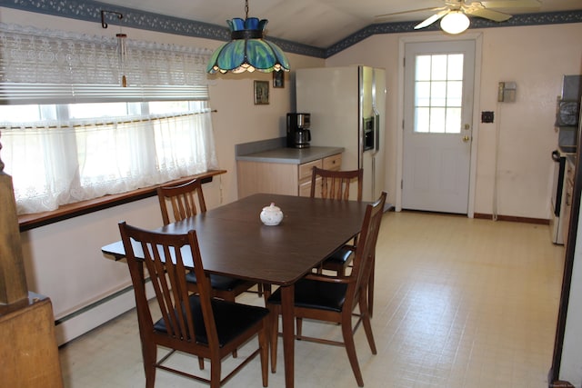 dining room with baseboards, light floors, ceiling fan, a baseboard radiator, and vaulted ceiling