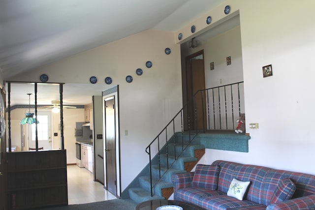 staircase featuring a ceiling fan, vaulted ceiling, and wood finished floors