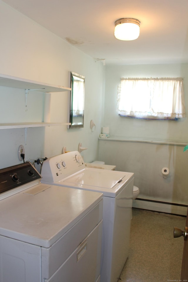 clothes washing area with baseboard heating, separate washer and dryer, and laundry area