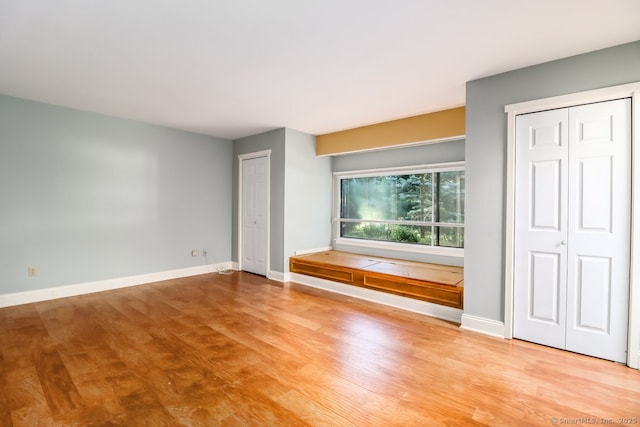 920 Heritage Vlg Unit A, Southbury, CT 06488 - unfurnished bedroom featuring wood finished floors and multiple closets