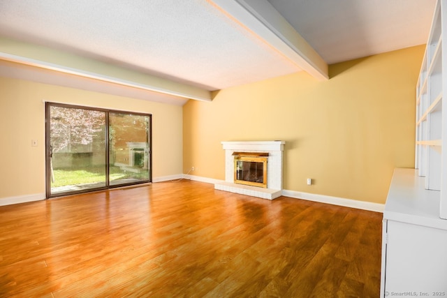 920 Heritage Vlg Unit A, Southbury, CT 06488 - unfurnished living room featuring beam ceiling, wood finished floors, and a glass covered fireplace