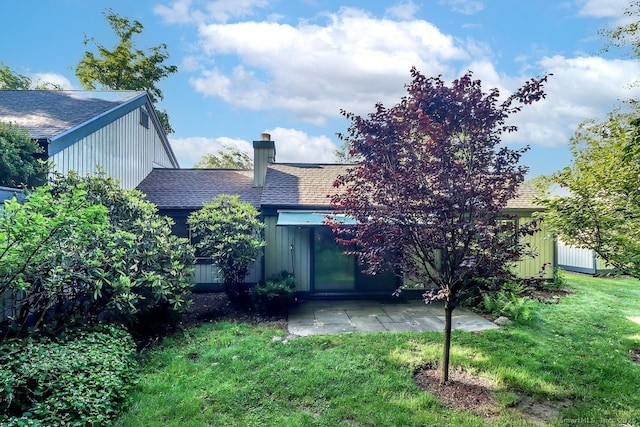 920 Heritage Vlg Unit A, Southbury, CT 06488 - rear view of house featuring a shingled roof, a lawn, a chimney, and a patio