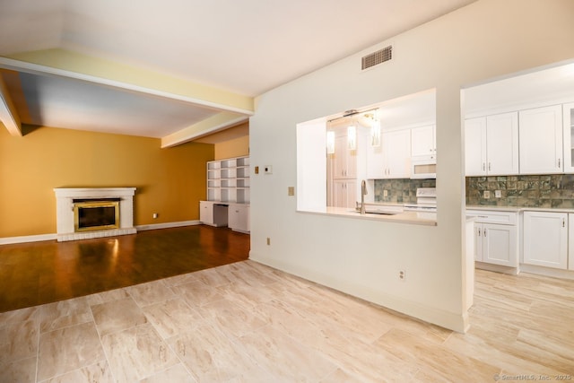 920 Heritage Vlg Unit A, Southbury, CT 06488 - unfurnished living room featuring a fireplace, beamed ceiling, and light wood finished floors