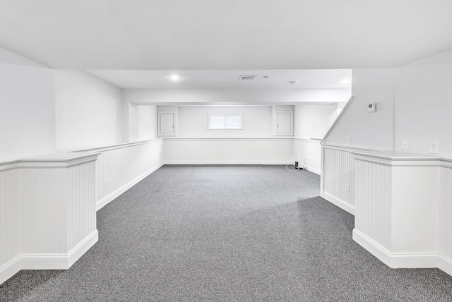 below grade area with carpet flooring, recessed lighting, visible vents, and wainscoting