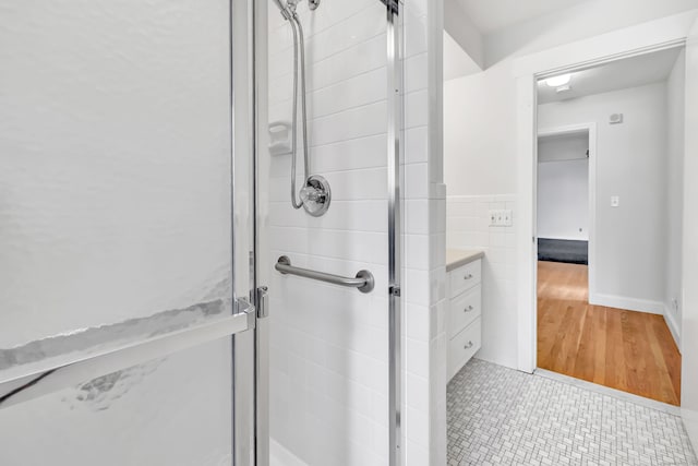 bathroom featuring a stall shower and tile walls