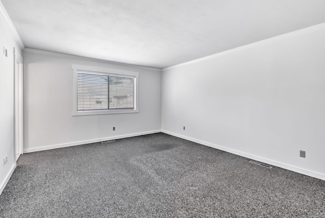 empty room featuring baseboards, visible vents, ornamental molding, and dark colored carpet