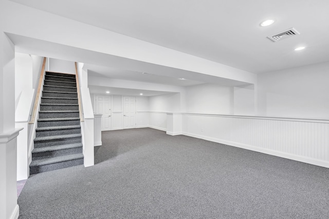 finished basement featuring recessed lighting, dark colored carpet, stairs, and visible vents