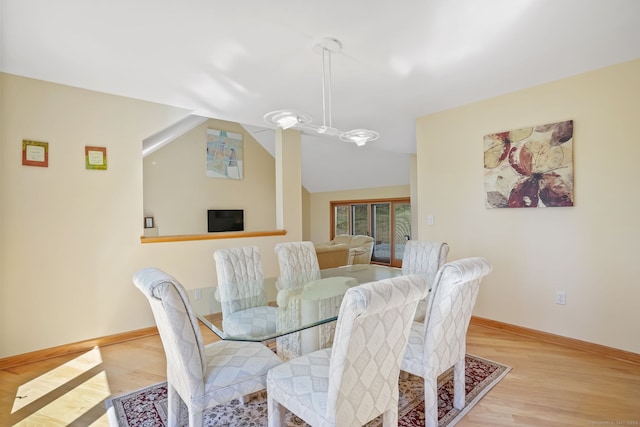 dining area with baseboards, lofted ceiling, and wood finished floors