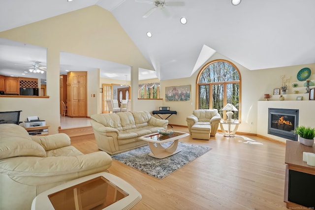 living area with recessed lighting, ceiling fan, a glass covered fireplace, and light wood-style floors