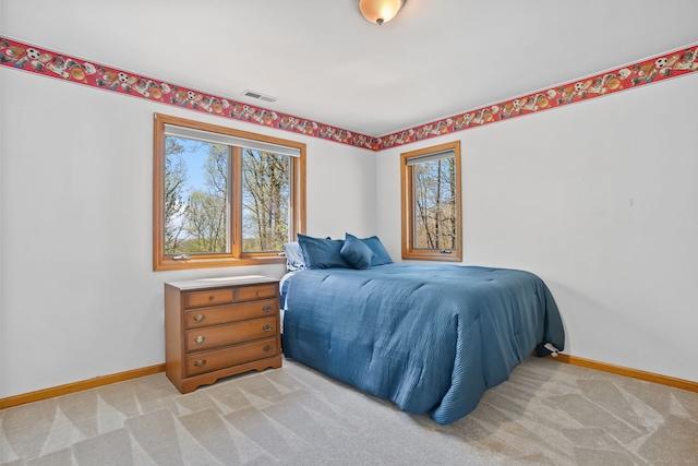 bedroom featuring baseboards, multiple windows, light carpet, and visible vents