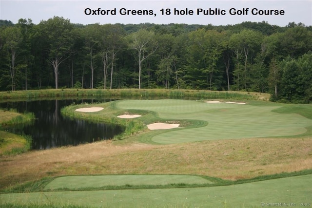 view of community featuring a water view, golf course view, and a forest view