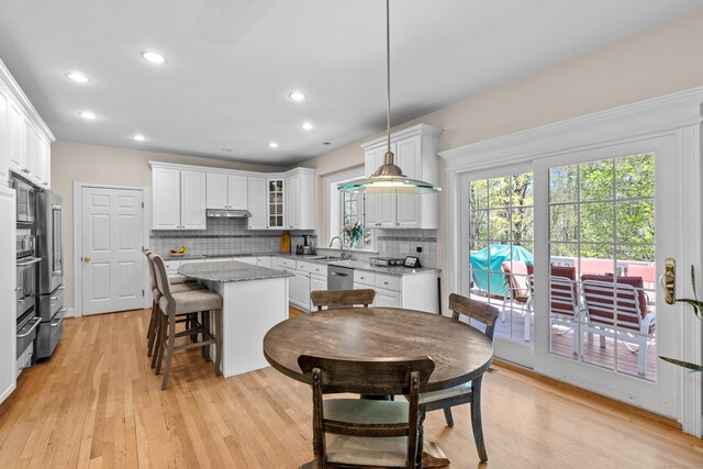 dining space with recessed lighting and light wood-type flooring