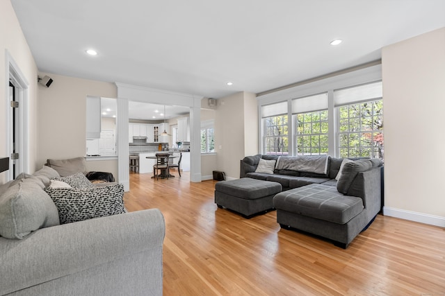 living room featuring recessed lighting, baseboards, and light wood-type flooring