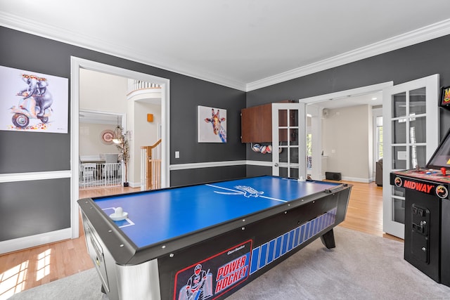 rec room featuring baseboards, ornamental molding, french doors, and wood finished floors