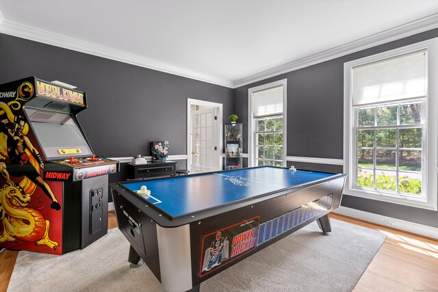 recreation room with crown molding, baseboards, and light wood-style floors