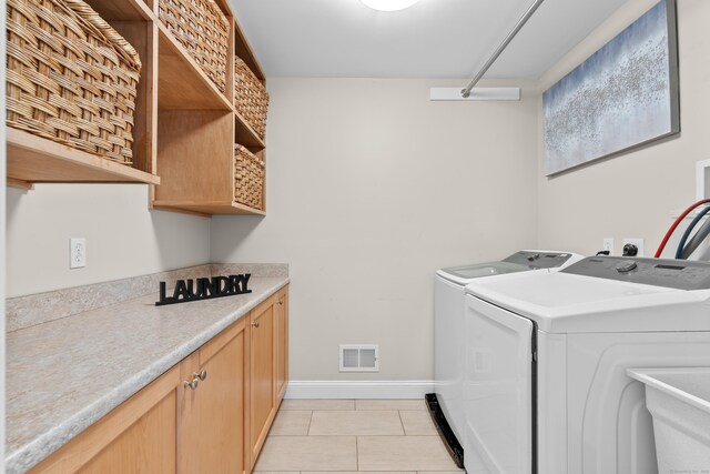 laundry area featuring visible vents, baseboards, cabinet space, independent washer and dryer, and light tile patterned floors