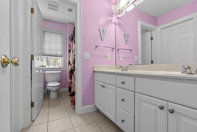 full bathroom featuring visible vents, double vanity, toilet, baseboards, and tile patterned floors