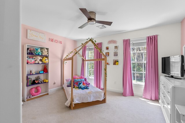 bedroom with baseboards, visible vents, light carpet, and ceiling fan