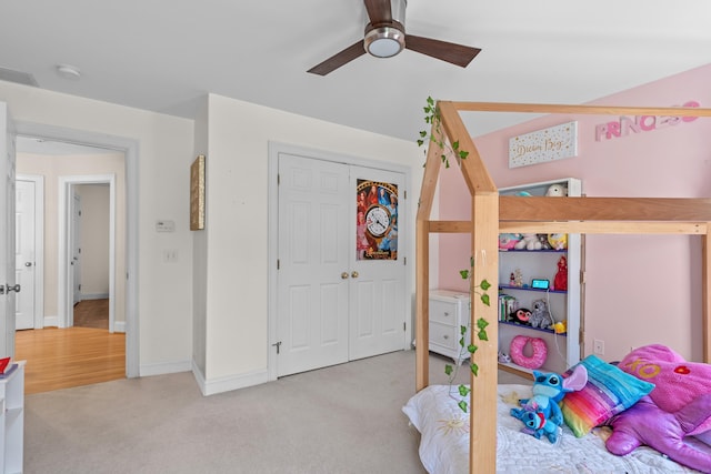 bedroom featuring a ceiling fan, baseboards, light carpet, and a closet