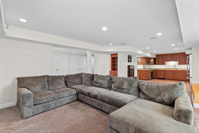 living area featuring recessed lighting, baseboards, and light colored carpet