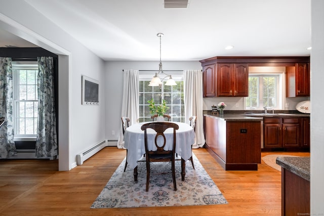 interior space with dark countertops, visible vents, a wealth of natural light, and a baseboard radiator
